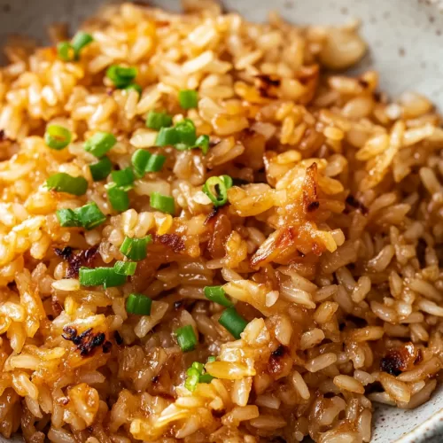 Golden-brown baked rice with a hint of melted butter served in a rustic dish.