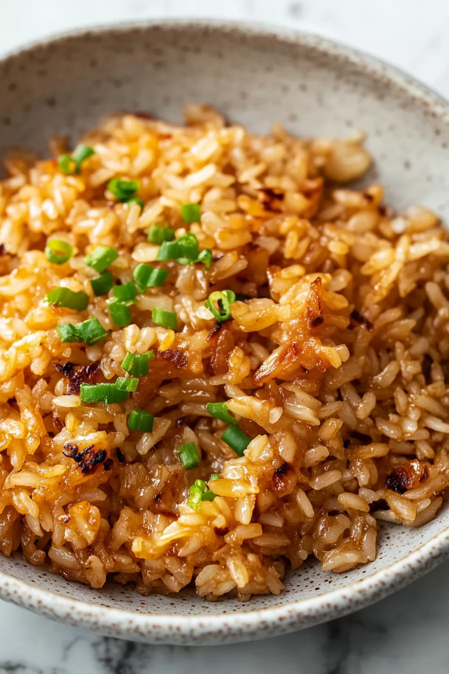 Golden-brown baked rice with a hint of melted butter served in a rustic dish.