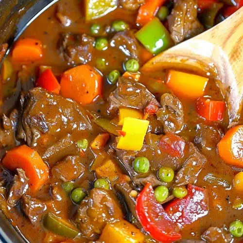 A vibrant stew featuring chunks of beef, peas, and bell peppers, perfect for a comforting meal.