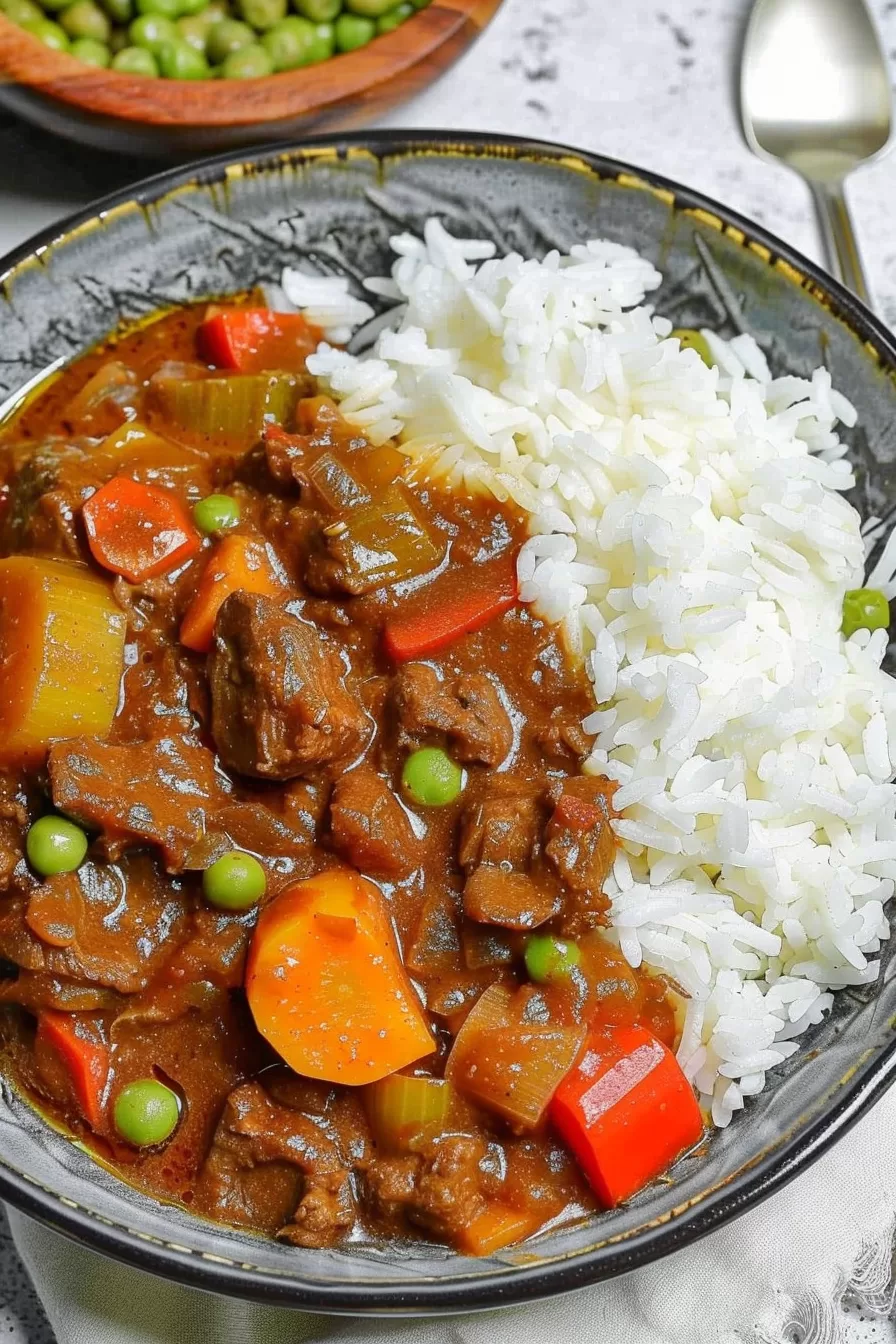 A serving of savory beef stew paired with steamed white rice, ready to enjoy.