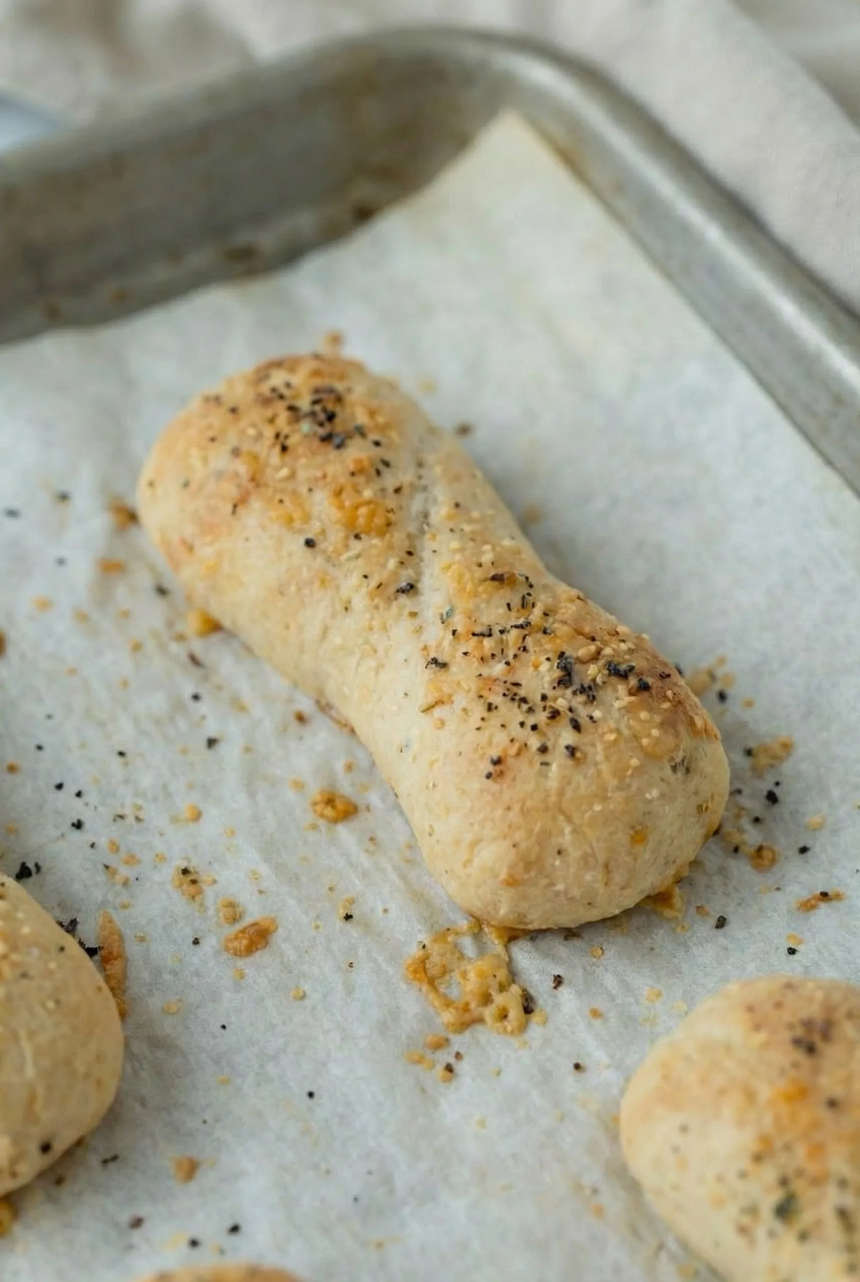 Close-up of a crispy pizza stick topped with garlic butter and Italian seasoning
