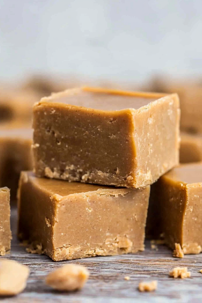 Artistic shot of peanut butter fudge squares with a blurred background highlighting their rich color and texture.