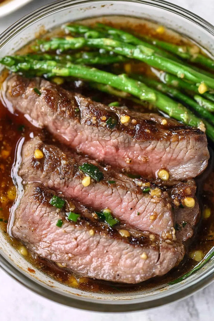 Grilled steak slices arranged on a serving platter, glistening with a savory marinade.