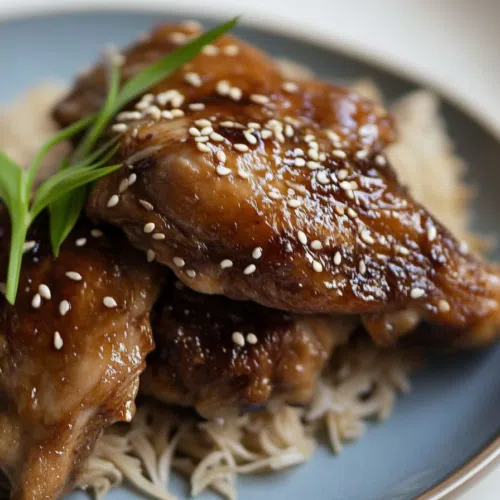 Close-up of tender, caramelized shoyu chicken thighs with a glossy, flavorful sauce.