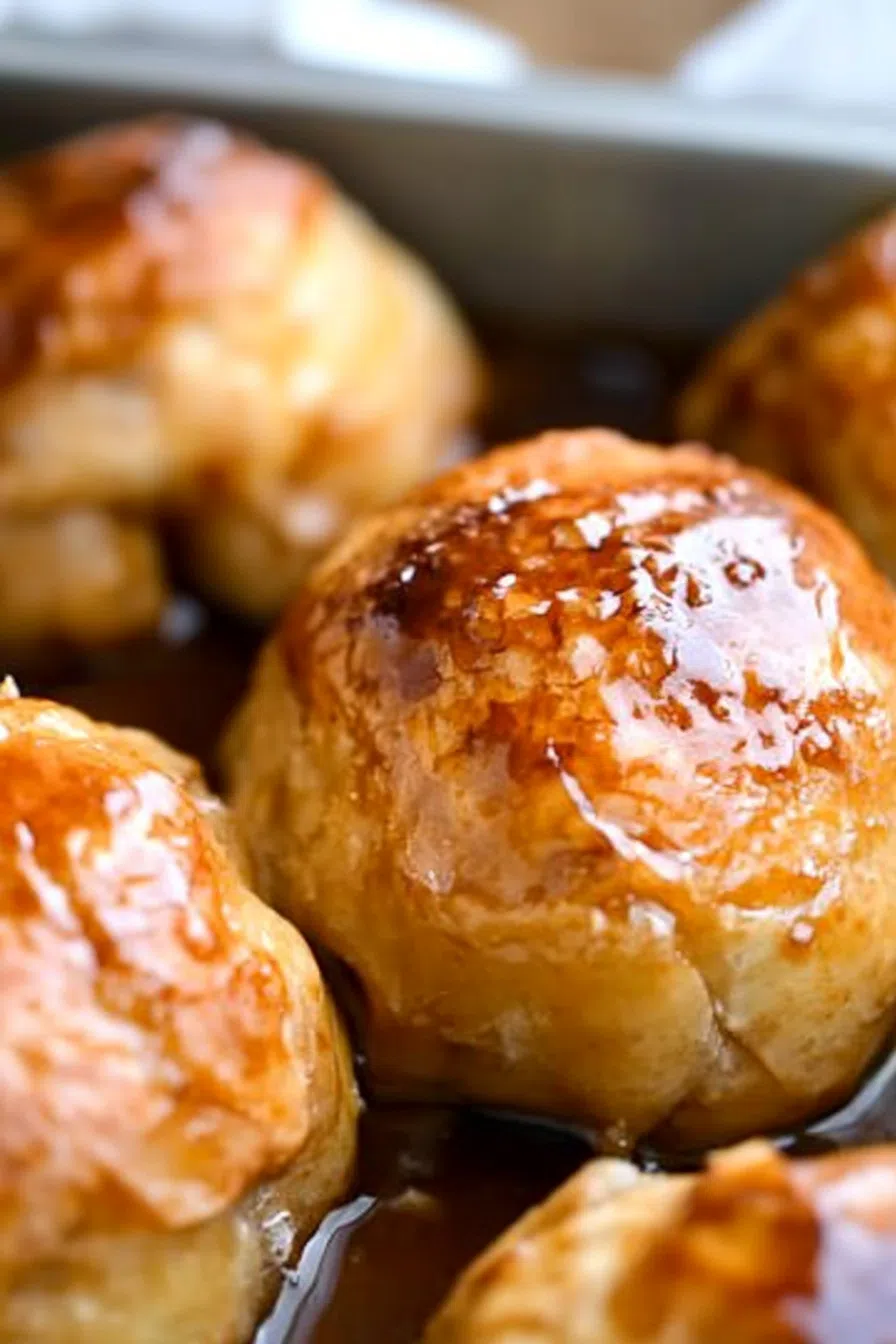 A beautiful presentation of an apple dumpling, garnished with cinnamon and a sprig of mint.