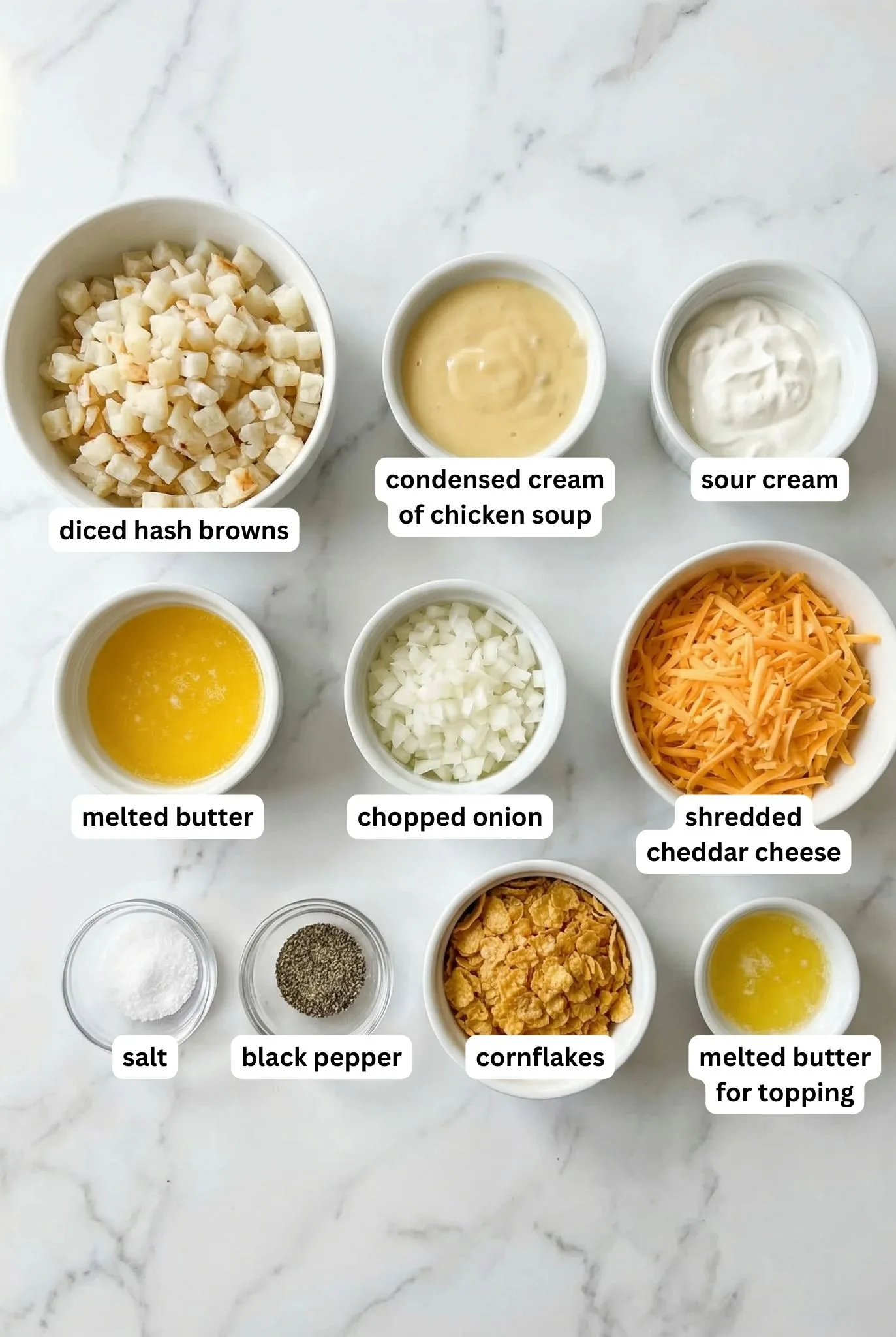 Ingredients for Amish Funeral Potatoes including diced hash browns, cream of chicken soup, sour cream, onion, butter, cheddar cheese, salt, pepper, and cornflakes topping