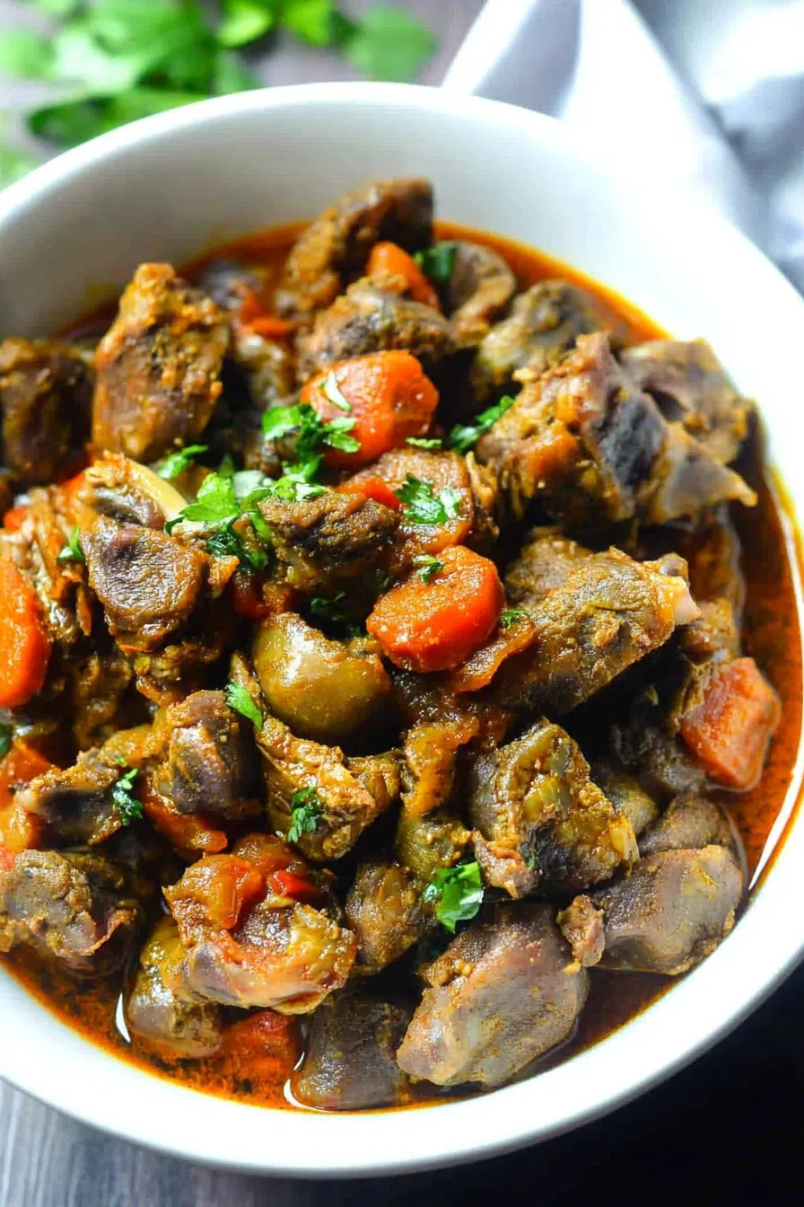 A hearty serving of braised chicken hearts and gizzards in a rich sauce, presented in a rustic bowl.