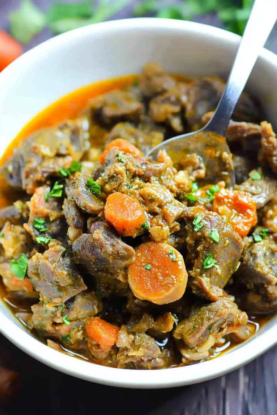 Tender and flavorful braised chicken hearts and gizzards, garnished with chopped green onions, served on a ceramic plate.