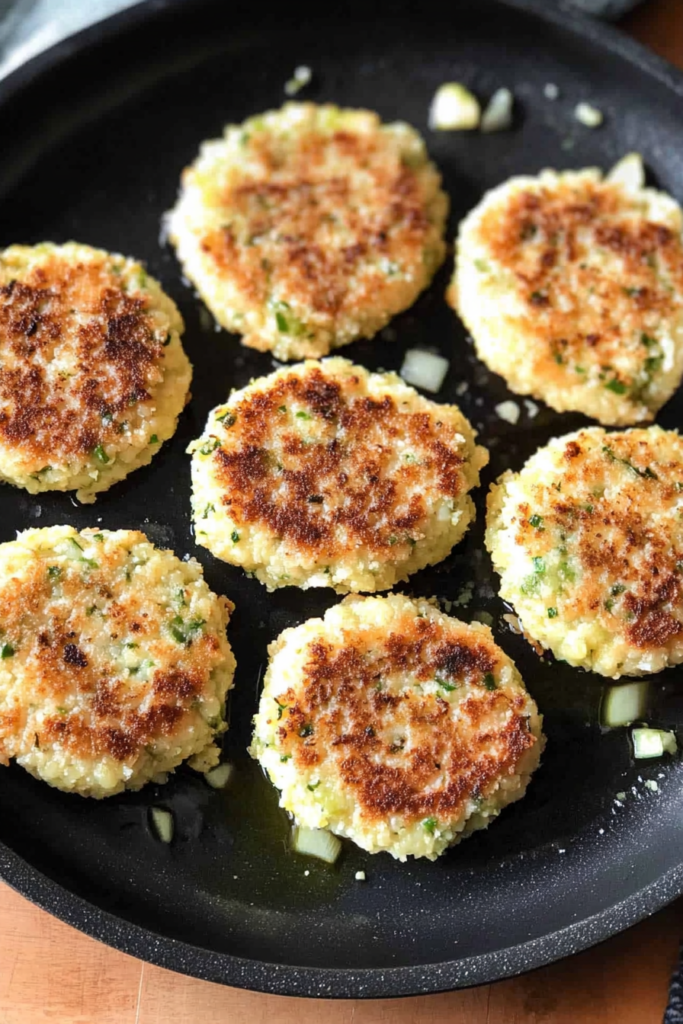 Top-down view of a batch of egg patties on a serving platter, with a sprinkle of chopped parsley.