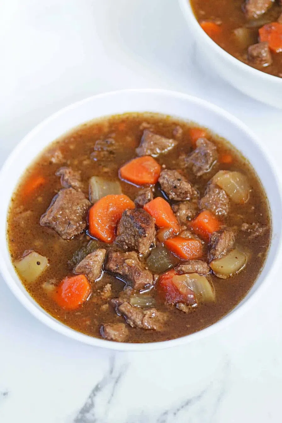 A hearty bowl of venison stew with chunks of tender meat and vegetables.