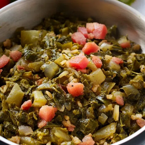 A bowl filled with colorful bell peppers, onions, and flaky fish mixed with callaloo.
