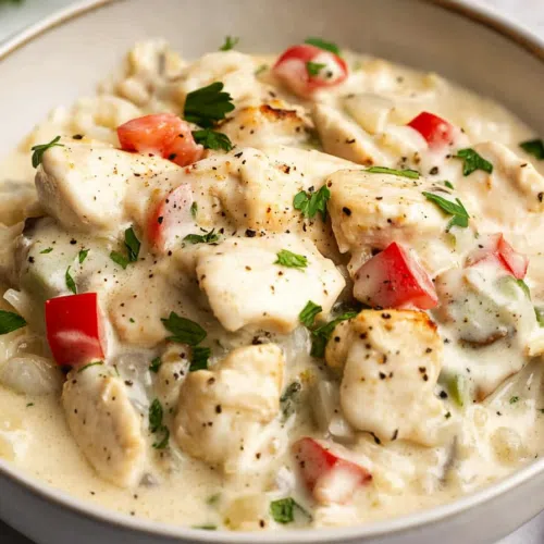 Creamy chicken and vegetable mixture served in a shallow white bowl.