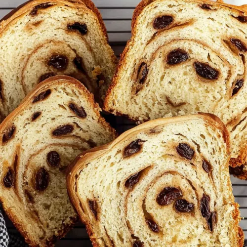A close-up of sliced bread revealing cinnamon-sugar layers and plump raisins.