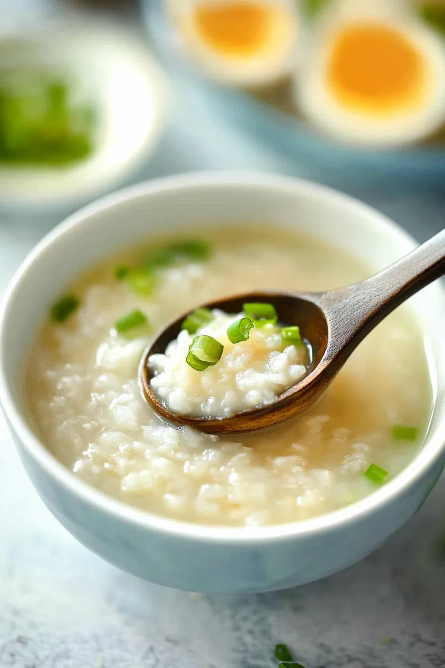 A close-up of a spoon scooping thick, warm porridge from a bowl.