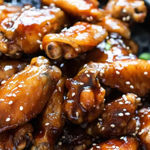 Chicken wings coated in a rich, sticky glaze, served on a plate.