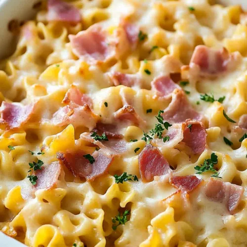 Close-up of a casserole dish filled with creamy noodles and crispy edges.