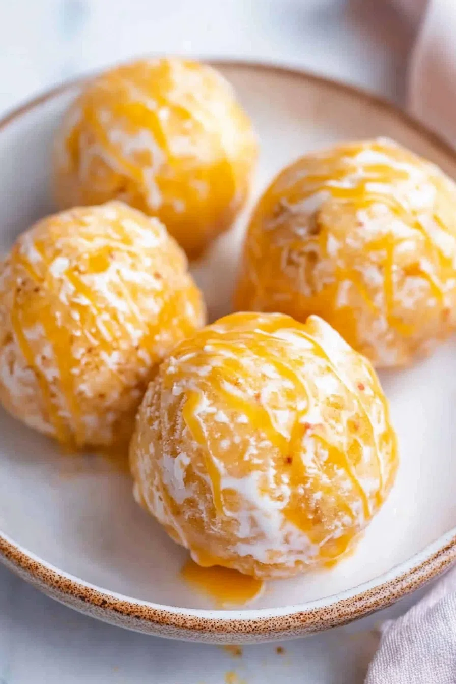 Close-up of a creamy frozen dessert topped with caramel sauce and toasted pecans.
