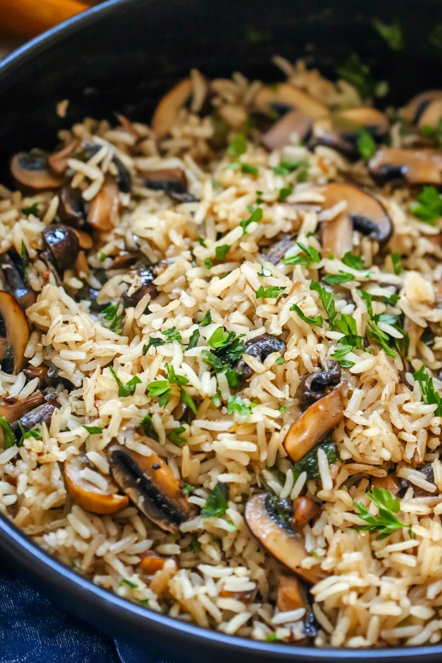 Close-up of fluffy rice with golden-brown mushroom slices on top.