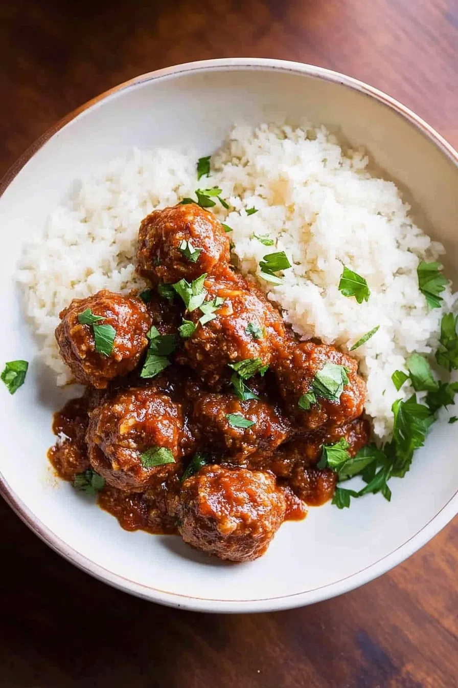 Close-up of tender meatballs with rice peeking through the surface.