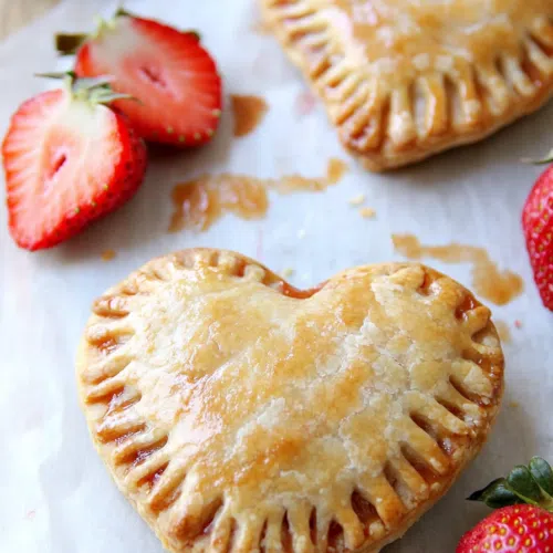 These adorable Strawberry Heart Hand Pies are as cute as they are delicious! Flaky crust, sweet jam, and vanilla glaze make them the perfect Valentine’s treat (or any time you want to spread some love!).