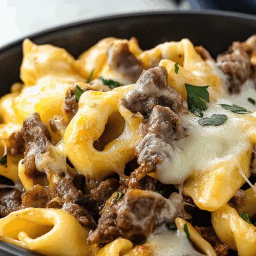 Creamy pasta dish in a skillet, topped with seared beef strips and melty cheese.