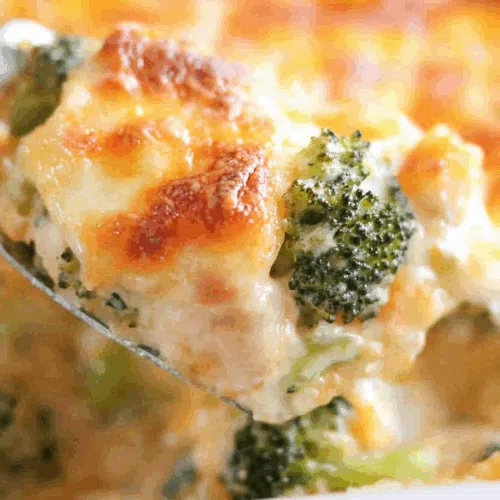 Spoonful being served, revealing layers of tender meat, sauce, and broccoli.