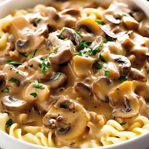 A comforting bowl of pasta topped with sautéed mushrooms and fresh herbs.
