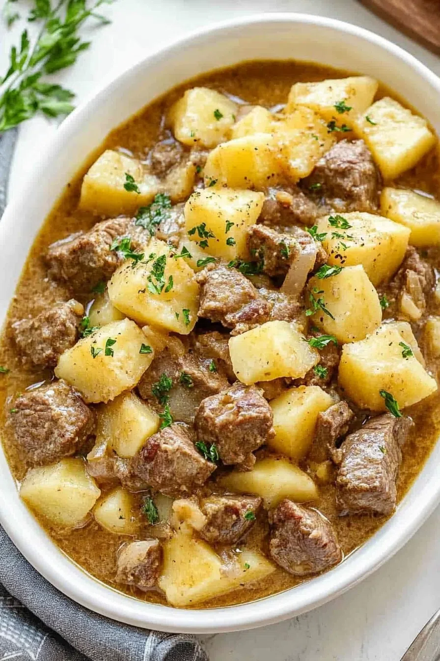 Sliced steak and seasoned potatoes in a creamy, savory sauce.