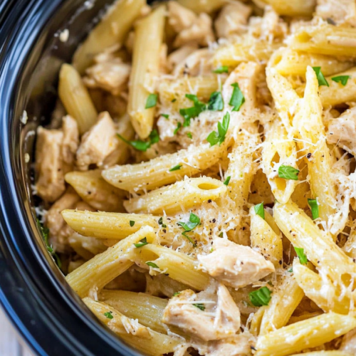 Close-up of tender chicken mixed with noodles and a rich, creamy sauce.