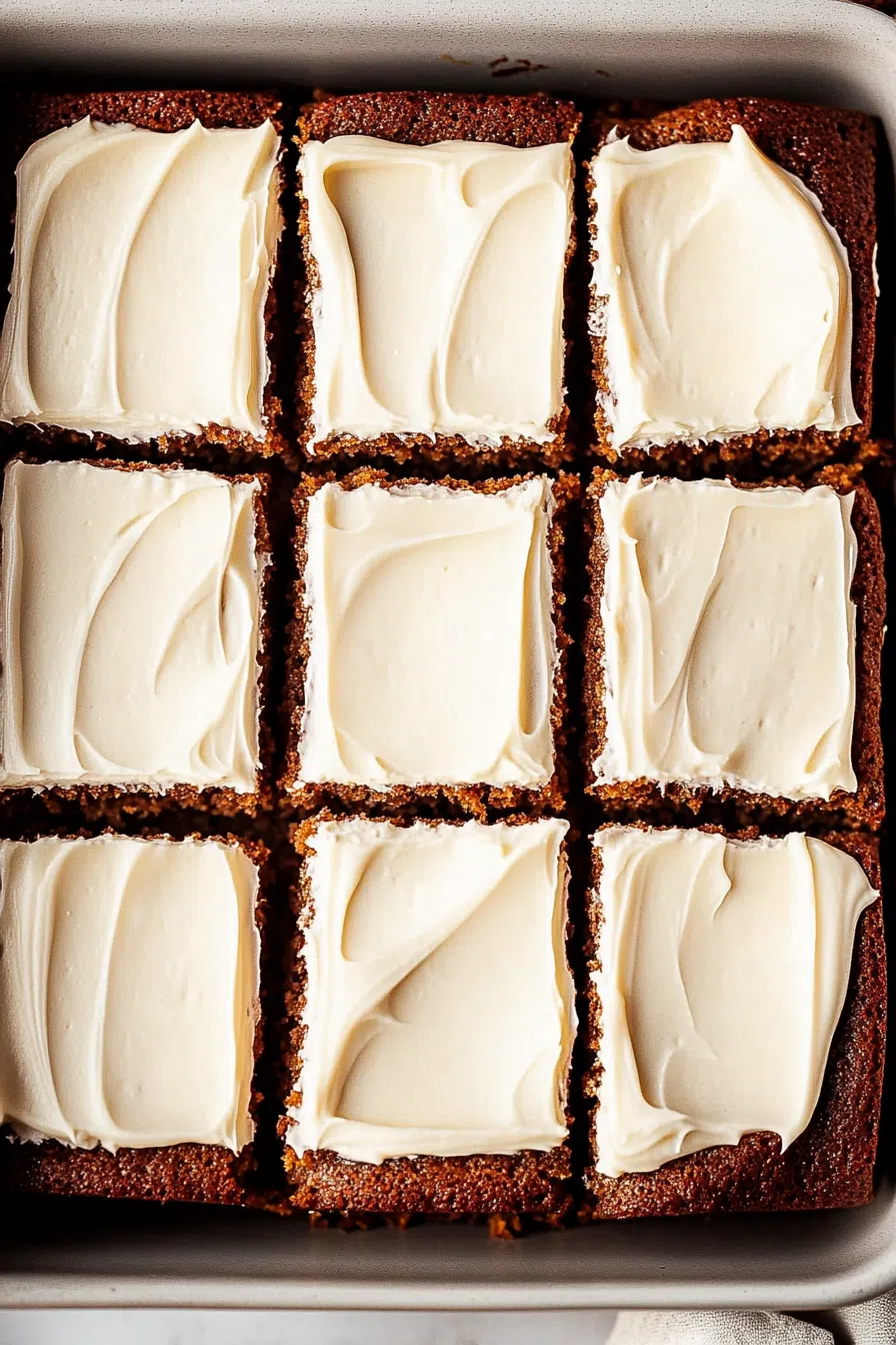 Overhead view of a tray of dark, fluffy cake with a smooth icing finish.