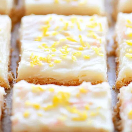 Overhead shot of dessert bars arranged on a serving plate with a few crumbs around.