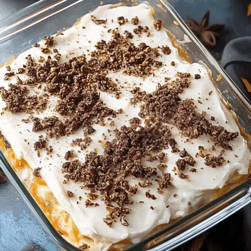 A layered dessert with whipped topping and crushed pecans in a glass dish.