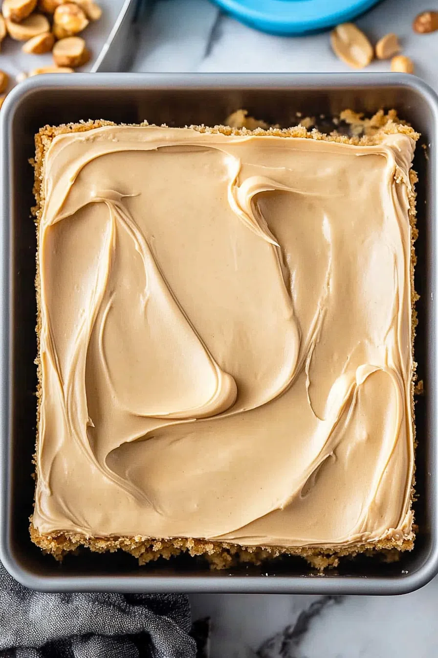 Overhead view of a freshly baked frosted cake in a pan.