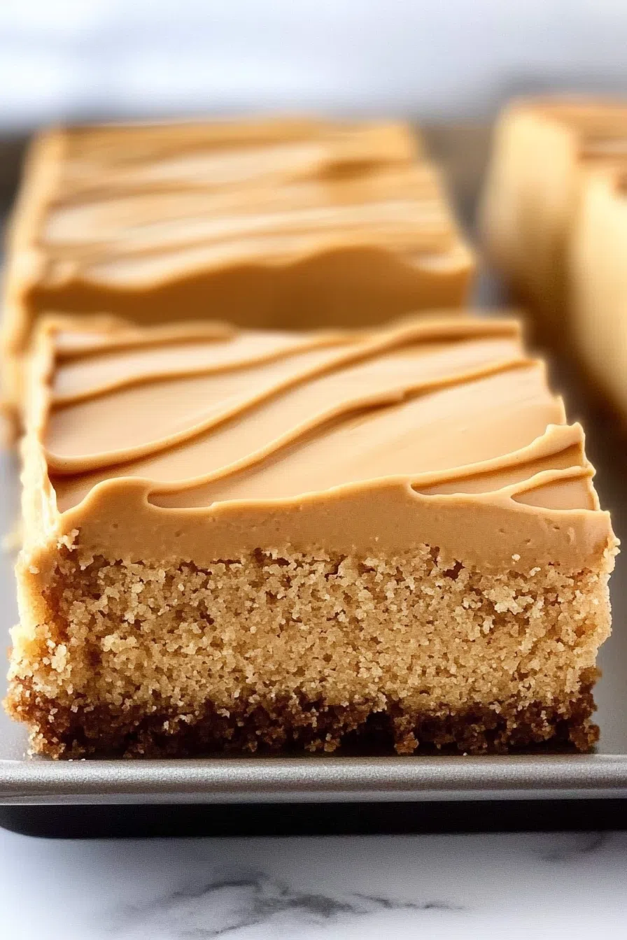 Close-up of a soft cake layer with smooth, rich frosting.