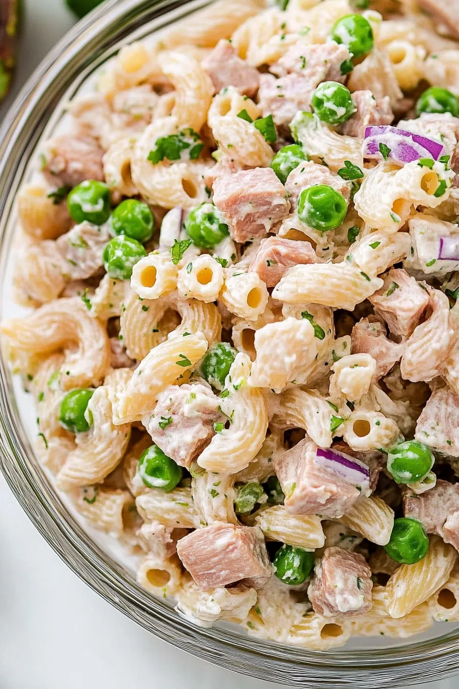 Close-up of chilled noodles tossed with creamy dressing and herbs.