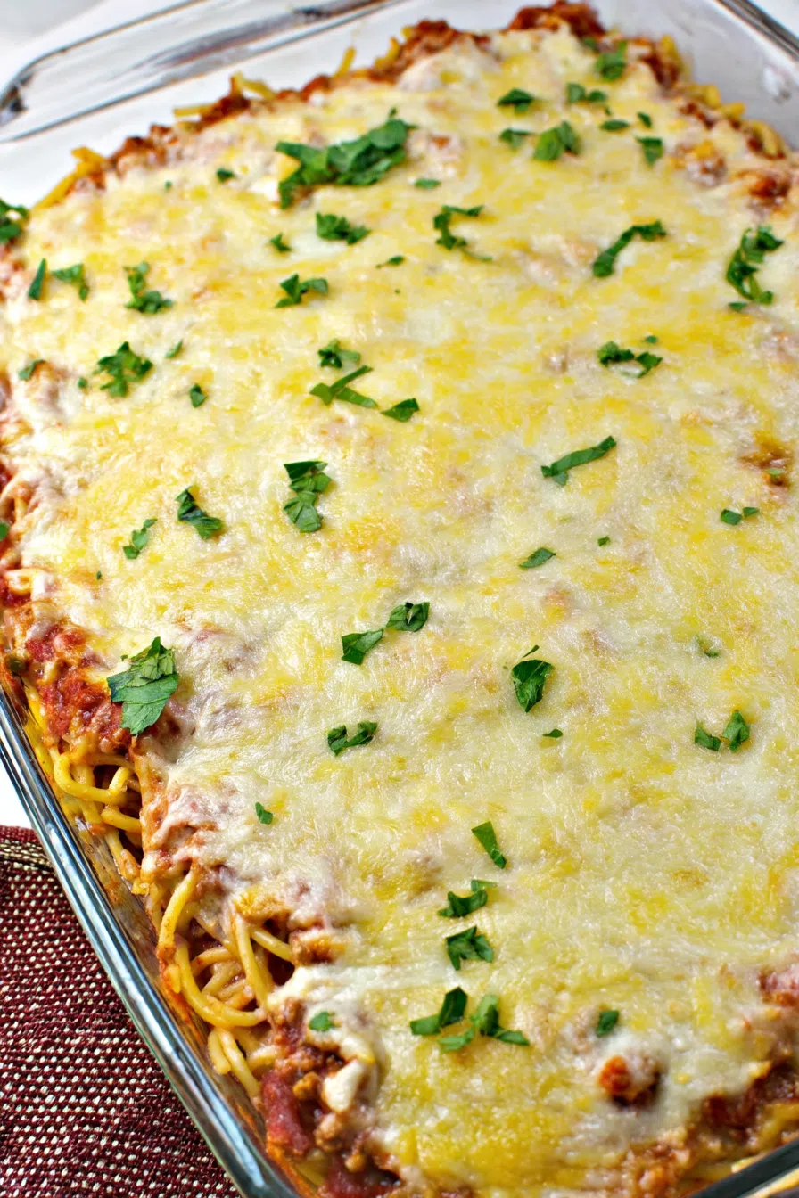 Baked noodles layered with sauce and melted cheese in a casserole dish.