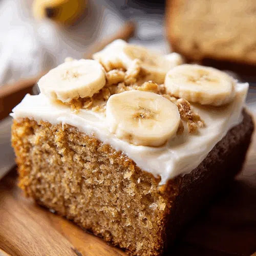 Frosted dessert squares arranged on a wooden board.