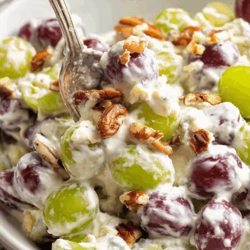 A serving spoon resting in a bowl of glossy, coated fruit.