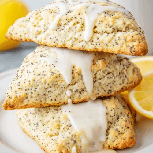 Close-up of golden baked treats with a crackled surface and citrus zest.