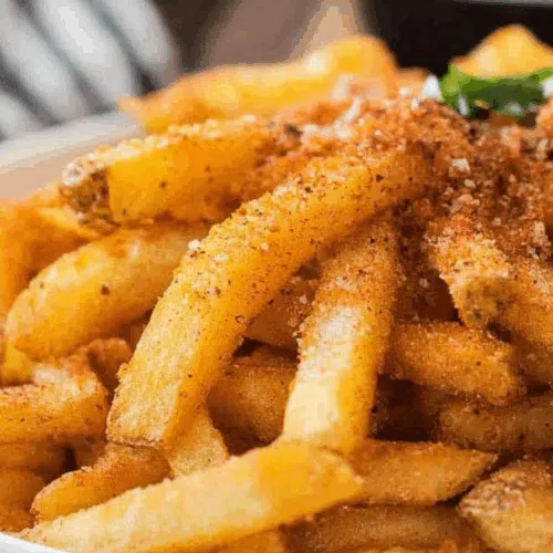 Close-up of crunchy fries coated with a spicy seasoning blend.