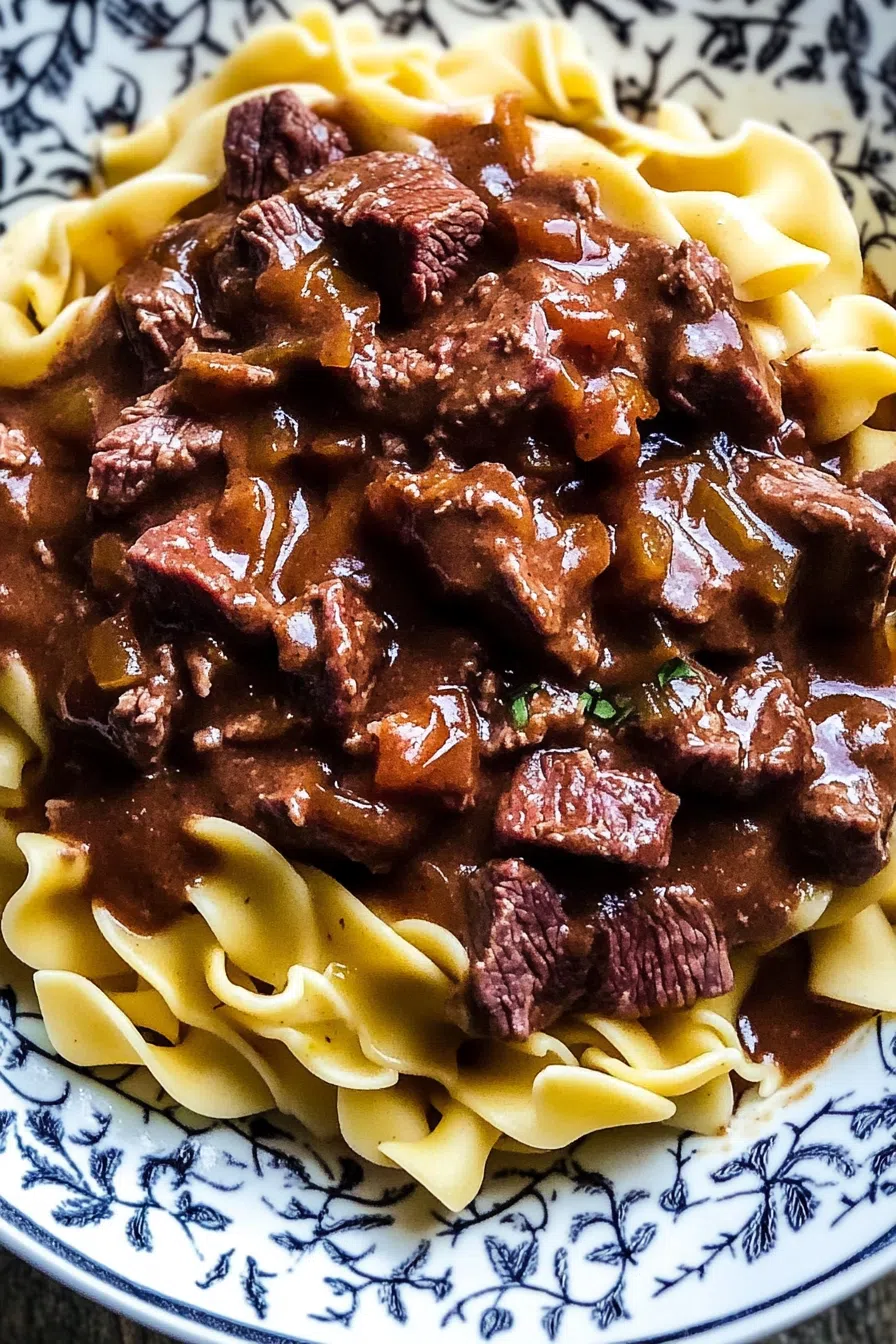Tender chunks of beef in rich gravy served over a bed of buttered noodles.
