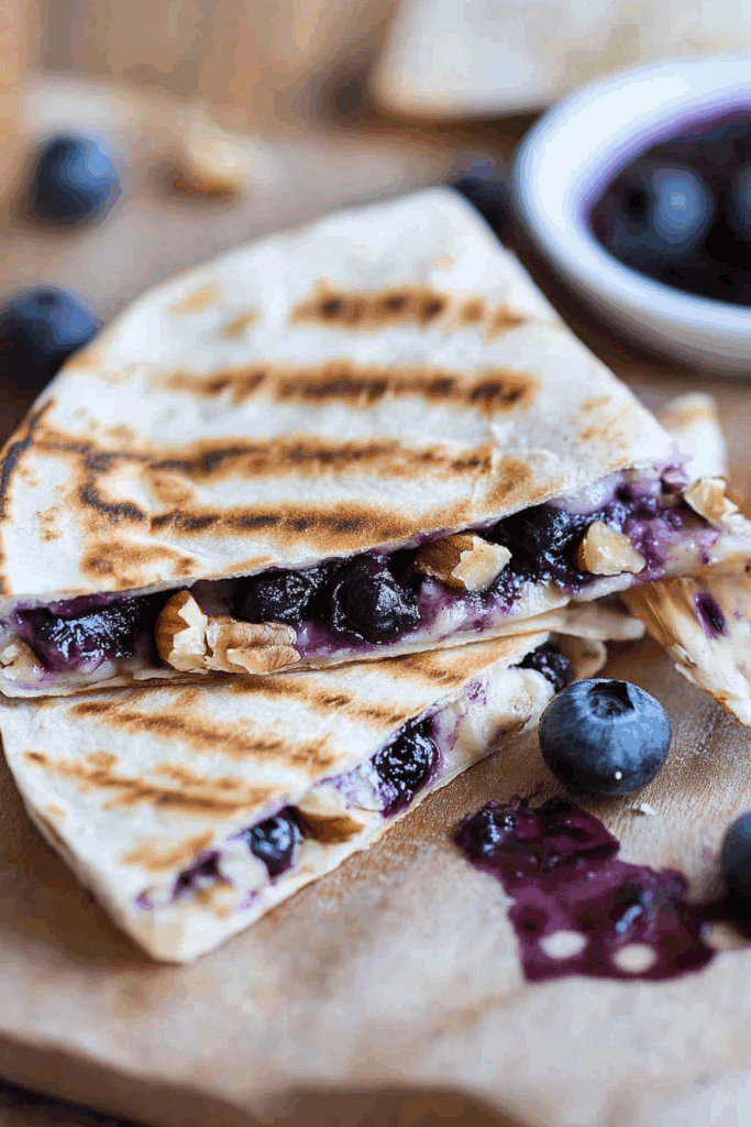 Close-up of a toasted wrap oozing with sweet berry mixture and creamy cheese.