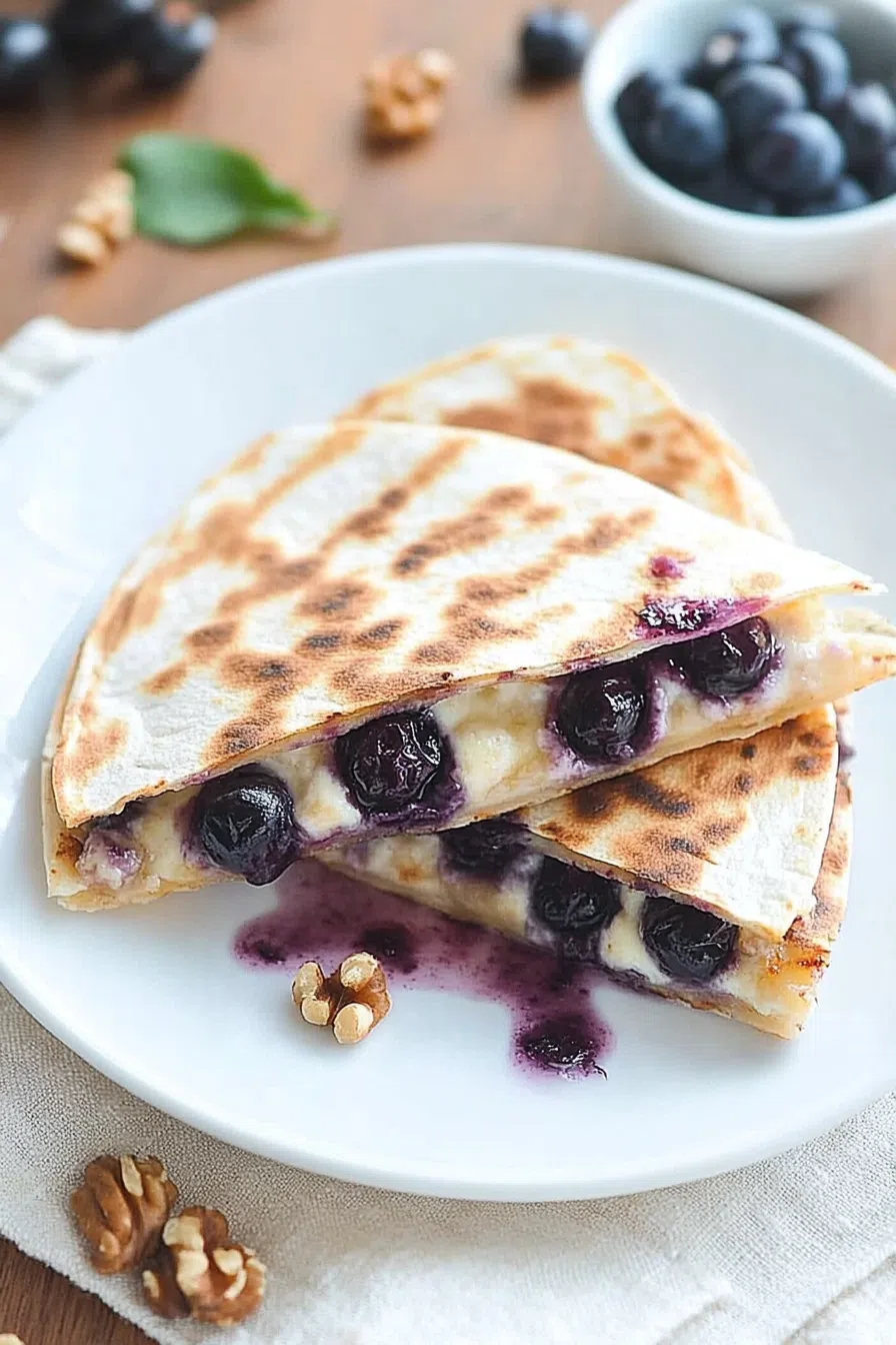 Golden-brown wedges on a plate with blueberries spilling from the center.