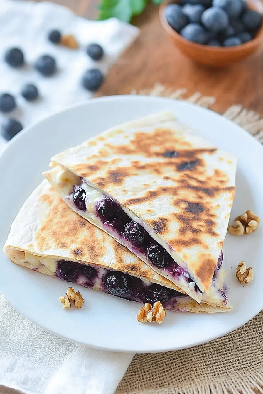 Crispy wedges on a plate with melted filling and fresh blueberries on the side.