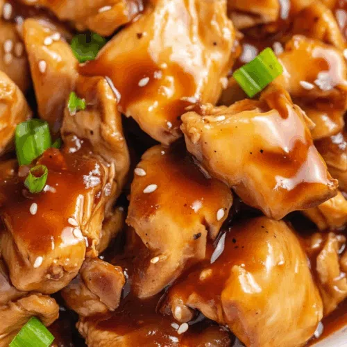 Close-up of glazed chicken pieces coated in a thick, glossy sauce.