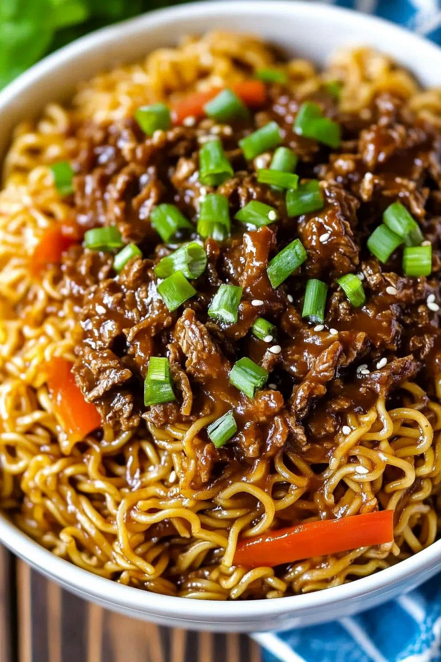 Overhead view of a comforting noodle soup garnished with green onions.