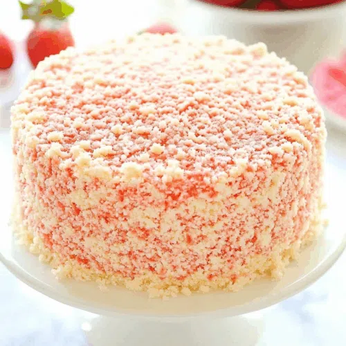 Thick, multi-textured dessert placed on a cake stand with crumbs scattered around.
