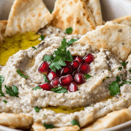 Close-up of a smooth, roasted vegetable spread with paprika and parsley on top