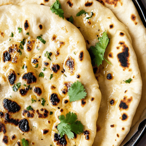 Golden-brown bread topped with melted butter and fresh herbs