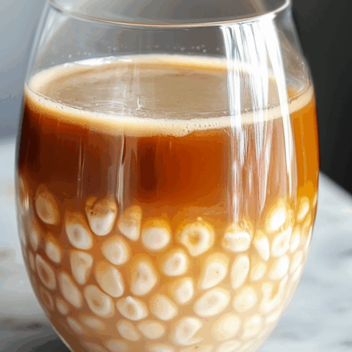 Overhead view of a chilled tea-based drink with a rich, layered appearance
